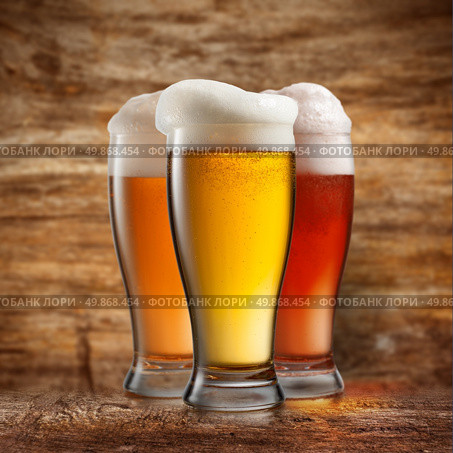 Different beer in glasses on wooden background. Стоковое фото, агентство Ingram Publishing / Фотобанк Лори