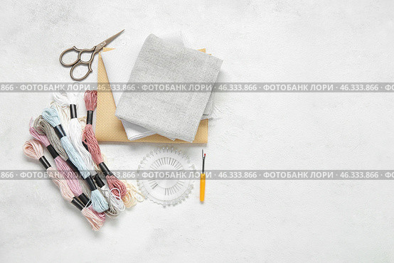 Different canvases with scissors, mouline threads and ball pins on grunge white background. Стоковое фото, фотограф Pixel_shot / Фотобанк Лори