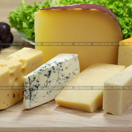 Different cheeses served on wooding cutting board. Стоковое фото, агентство Ingram Publishing / Фотобанк Лори