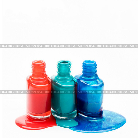 different shades nail polish spilled around three opened bottles. Стоковое фото, агентство Ingram Publishing / Фотобанк Лори