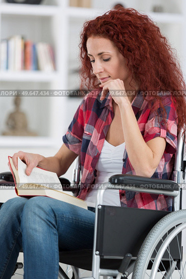 disabilty and handicap young disabled woman on wheelchair reads book. Стоковое фото, агентство Ingram Publishing / Фотобанк Лори