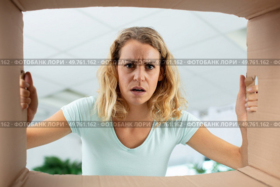 disappointed millennial female client open post shipping package. Стоковое фото, агентство Ingram Publishing / Фотобанк Лори