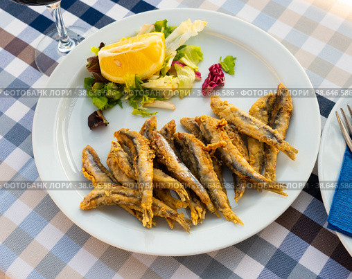 Dish with fried sardines, pilchards or anchovies in batter for traditional Spanish meal. Стоковое фото, фотограф Яков Филимонов / Фотобанк Лори