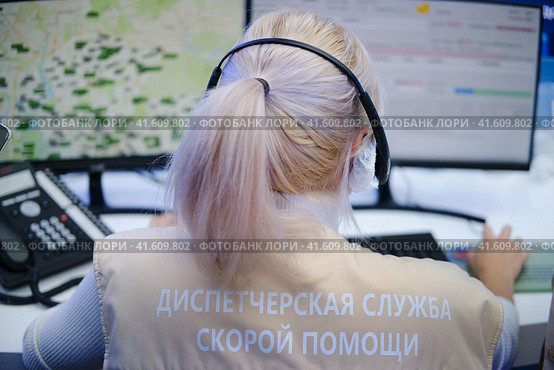 Dispatching service of the Moscow ambulance. Rear view of female customer support operator using headset and computer in call center - Moscow, Russia, August 30, 2023. Редакционное фото, фотограф Андрей Журавлев / Фотобанк Лори