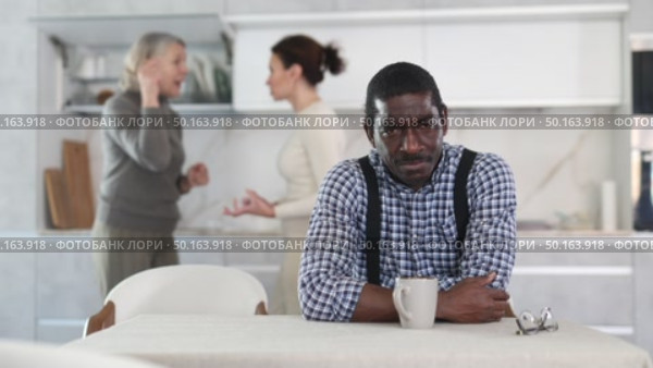 Dissatisfied man is tired of domestic quarrels. Two women quarreling in the background. Стоковое видео, видеограф Яков Филимонов / Фотобанк Лори
