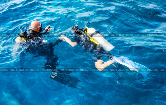 Diver instructor with a girl tourist swim in the Red Sea. Стоковое фото, фотограф Артем Курутин / Фотобанк Лори