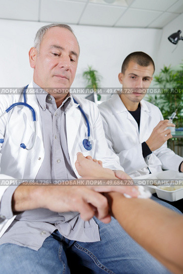 doctor disinfecting patient before injection. Стоковое фото, агентство Ingram Publishing / Фотобанк Лори