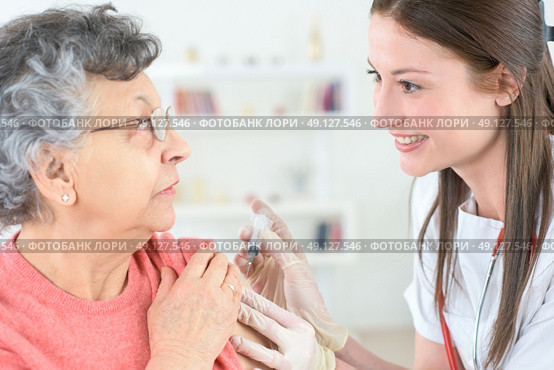 doctor inject influenza vaccine into old woman patient. Стоковое фото, агентство Ingram Publishing / Фотобанк Лори