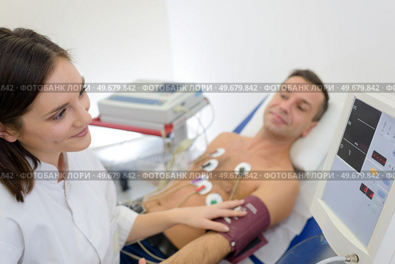 doctor measuring blood pressure of patient with electrodes. Стоковое фото, агентство Ingram Publishing / Фотобанк Лори