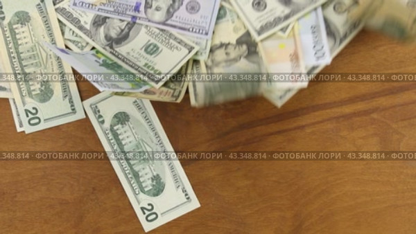 Доллары и евро развеваются на ветру вместе с деревянной поверхностью. Dollars blown and euros by the wind  with a wooden surface. Стоковое видео, видеограф Александр Собко / Фотобанк Лори