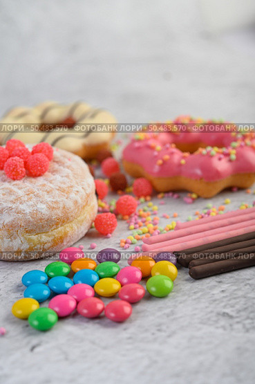 Donuts sprinkled with icing sugar and candy on a white background. Стоковое фото, агентство Ingram Publishing / Фотобанк Лори