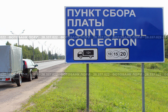 Дорожный указатель Пункт сбора платы на фоне легкового автомобиля с прицепом летом. Стоковое фото, фотограф Илья Илмарин / Фотобанк Лори