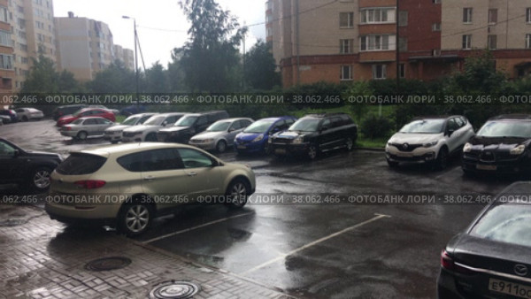 Дождь идет на парковке внутреннего двора жилого комплекса. Припаркованные автомобили под дождем (2022 год). Редакционное видео, видеограф Кекяляйнен Андрей / Фотобанк Лори
