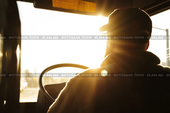 Driver turns steering wheel of truck, bus at sunset time. Skilled chauffeur drives lorry to deliver freight. Cargo shipping service. Drives Journey. Drivers silhouette against a vivid sundown. Travel. Стоковое AI-изображение, AI-художник Марина Демидюк / Фотобанк Лори
