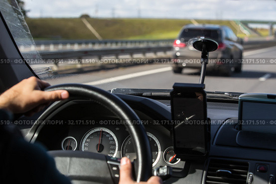 Driver's hand on the steering wheel of a driving car. Стоковое фото, фотограф Юрий Бизгаймер / Фотобанк Лори