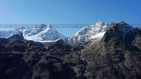Drone flying along snow covered white mountain glacier in sunny autumn day. Стоковое видео, видеограф Кирилл Трифонов / Фотобанк Лори