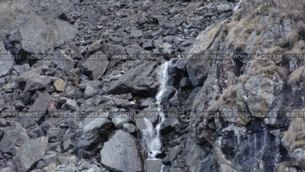 Drone flying away from rapid stream of mountain waterfall in autumn day. Стоковое видео, видеограф Кирилл Трифонов / Фотобанк Лори