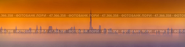 Dubai, United Arab Emirates - Jan 12 2024, Panoramic view of downtown Dubai skyscrapers, with Burj Khalifa in the middle, at dawn in a haze, a view from the sea, Dubai, United Arab Emirates. Стоковое фото, фотограф Сергей Богомяко / Фотобанк Лори