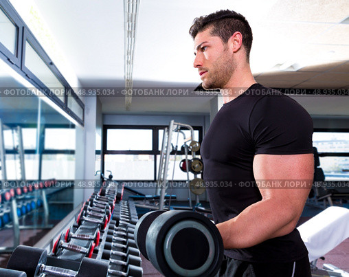 Dumbbell man at gym workout biceps fitness weightlifting. Стоковое фото, агентство Ingram Publishing / Фотобанк Лори