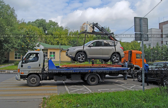Два эвакуатора увозят автомобиль, припаркованный с нарушением правил дорожного движения (2017 год). Редакционное фото, фотограф Александр Замараев / Фотобанк Лори