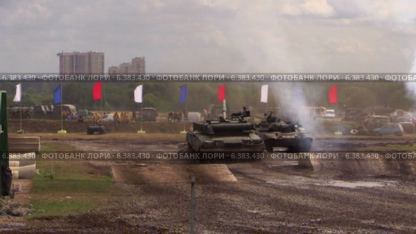 Два танка движутся по военному полигону. Танк Т-90А стреляет во время прыжка с рампы. (2014 год). Редакционное видео, видеограф Арташес Оганджанян / Фотобанк Лори