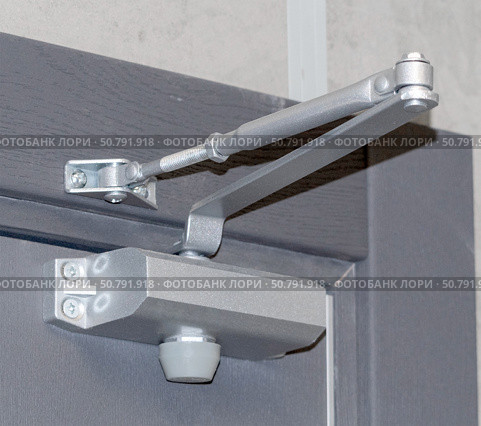 Дверной металлический доводчик, установленный на двери. Automatic hydraulic device, leaver hinge door closer holder on a white background. Стоковое фото, фотограф Татьяна Д / Фотобанк Лори