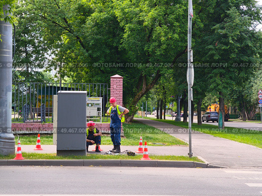 Двое рабочих у электрического шкафа на городской улице. Ремонт неисправного светофора. Редакционное фото, фотограф Мария Сергеева / Фотобанк Лори