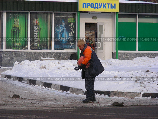 Дворник-гастарбайтер зимой посыпает улицу реагентами. Уссурийская улица. Район Гольяново. Город Москва (2012 год). Редакционное фото, фотограф lana1501 / Фотобанк Лори