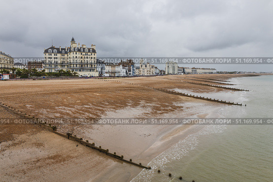 Eastbourne seafront with wooden groynes and Victorian hotels. Eastbourne, UK, 2 July 2024. Редакционное фото, фотограф Zydrius Tartenis / Фотобанк Лори