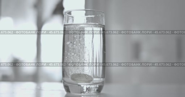 Effervescent aspirin pill in a glass of wate. Soluble tablet shot on super slow motion camera 1000 fps. Стоковое видео, видеограф Андрей Армягов / Фотобанк Лори