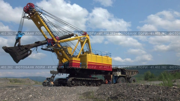 Экскаватор ЭКГ-8И и карьерный самосвал на горном полигоне (2019 год). Редакционное видео, видеограф Олег Хархан / Фотобанк Лори