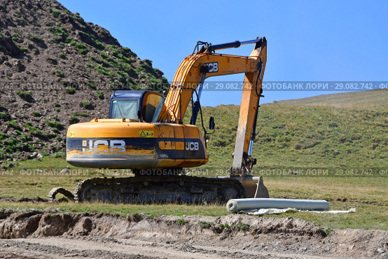 Экскаватор JCB на строительной площадке горнолыжного курорта "Романтик" в Архызе (2018 год). Редакционное фото, фотограф Овчинникова Ирина / Фотобанк Лори