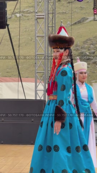 ELANTSY, IRKUTSK REGION, RUSSIA - July 5, 2025: Erdyn Games – festival of nomadic peoples of Eurasia. Vertical video of beautiful Buryat girl in beauty contest on open stage in national blue dress. Редакционное видео, видеограф Виктория Катьянова / Фотобанк Лори