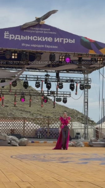 ELANTSY, IRKUTSK REGION, RUSSIA - July 5, 2025: Erdynskie Games– festival of nomadic peoples of Eurasia. Beautiful Buryat girl in red costume on open stage in Beauty Contest. Vertical video. Редакционное видео, видеограф Виктория Катьянова / Фотобанк Лори