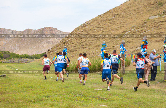 ELANTSY VILLAGE, IRKUTSK REGION, RUSSIA - July 5, 2025: Erdyn Games - festival of nomadic peoples of Eurasia. Athletes run traditional cross around sacred mountain of Erd on summer sunny day. Редакционное фото, фотограф Виктория Катьянова / Фотобанк Лори