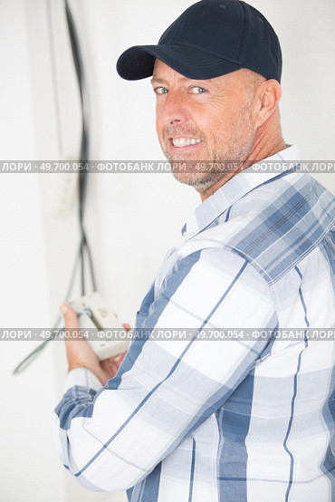 elderly electrician working on wiring installation. Стоковое фото, агентство Ingram Publishing / Фотобанк Лори