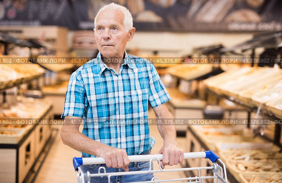 Elderly man buying bread and pastries in grocery section of the supermarket. Стоковое фото, фотограф Татьяна Яцевич / Фотобанк Лори