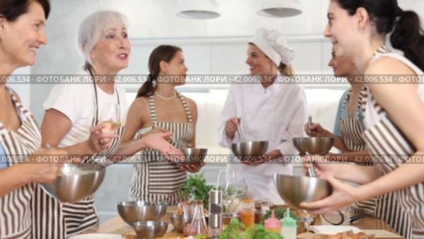 Elderly woman holds glass of cool white wine in hands and converse with participant at culinary courses. Стоковое видео, видеограф Яков Филимонов / Фотобанк Лори