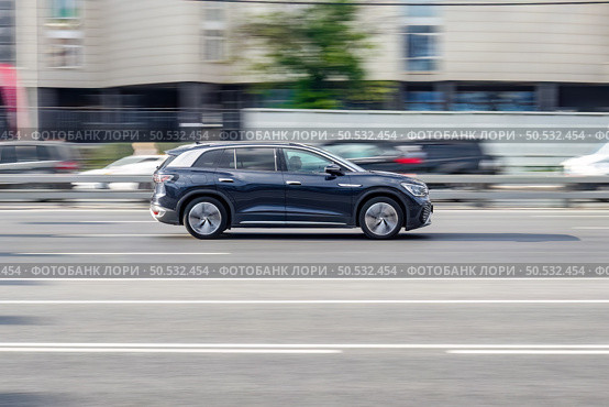 Electric crossover SUV Volkswagen ID.6 Crozz driving in motion blur on city streets. Редакционное фото, фотограф Константин Григорьев / Фотобанк Лори