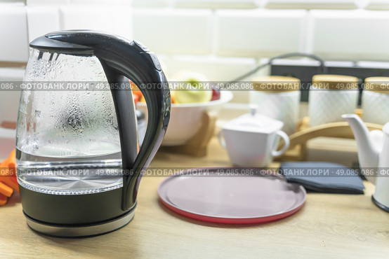 Electric kettle stands on the kitchen table. Стоковое фото, фотограф Дмитрий Попов / Фотобанк Лори
