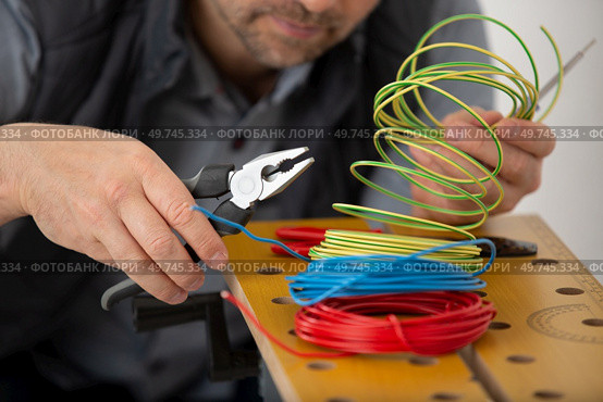 electrician engineer works with electric cable wires. Стоковое фото, агентство Ingram Publishing / Фотобанк Лори