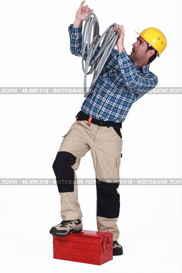Electrician swamped with cables. Стоковое фото, агентство Ingram Publishing / Фотобанк Лори