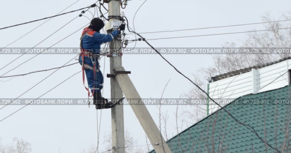 Electricity. An electrician installs an electric energy meter by climbing an electric pole. (2023 год). Редакционное видео, видеограф Сергей Медведев / Фотобанк Лори