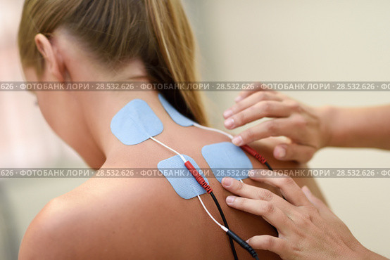 Electro stimulation in physical therapy to a young woman. Medical check at the shoulder in a physiotherapy center. Стоковое фото, фотограф Javier Sánchez Mingorance / Ingram Publishing / Фотобанк Лори