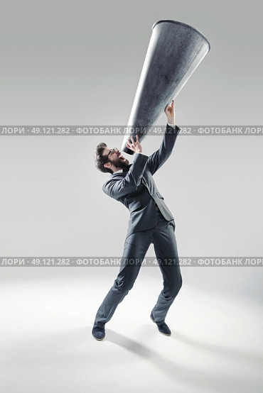 Elegant manager yelling over the huge megaphone. Стоковое фото, агентство Ingram Publishing / Фотобанк Лори