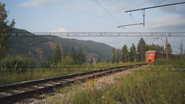 Электричка проезжает по железной дороге (город Дивногорск) (2014 год). Редакционное видео, видеограф Konstantin Kartashov / Фотобанк Лори