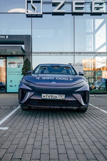 Электромобиль Rising Auto R7 перед зданием дилерского центра. Среднеразмерный электромобиль-кроссовер, выпускаемый компанией SAIC Motor (2024 год). Редакционное фото, фотограф Константин Григорьев / Фотобанк Лори