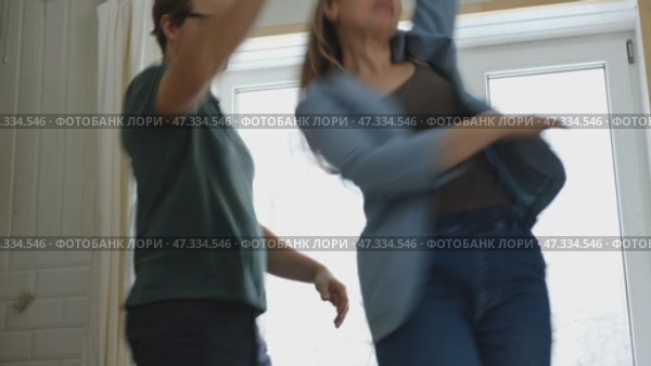 Emotional Dance. Middle-aged Couple Dancing Together Embrace at Home. Mature Couple dancing bonding, smiling and moving to the rhythm in a romantic vibe enjoying their anniversary. Active relationship. Стоковое видео, видеограф Марина Демидюк / Фотобанк Лори