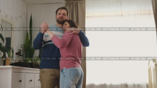 Emotional Dance. Middle-aged Couple Dancing Together Embrace at Home. Mature Couple dancing bonding, smiling and moving to the rhythm in a romantic vibe enjoying their anniversary. Active relationship. Стоковое видео, видеограф Марина Демидюк / Фотобанк Лори