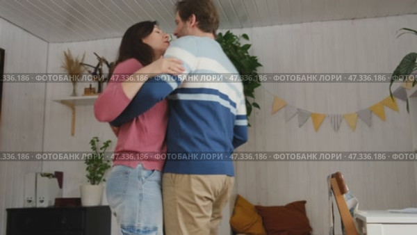 Emotional Dance. Middle-aged Couple Dancing Together Embrace at Home. Mature Couple dancing bonding, smiling and moving to the rhythm in a romantic vibe enjoying their anniversary. Active relationship. Стоковое видео, видеограф Марина Демидюк / Фотобанк Лори